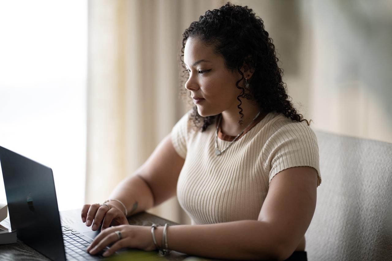 Priscila Santos, de perfil, durante um atendimento online em ambiente acolhedor